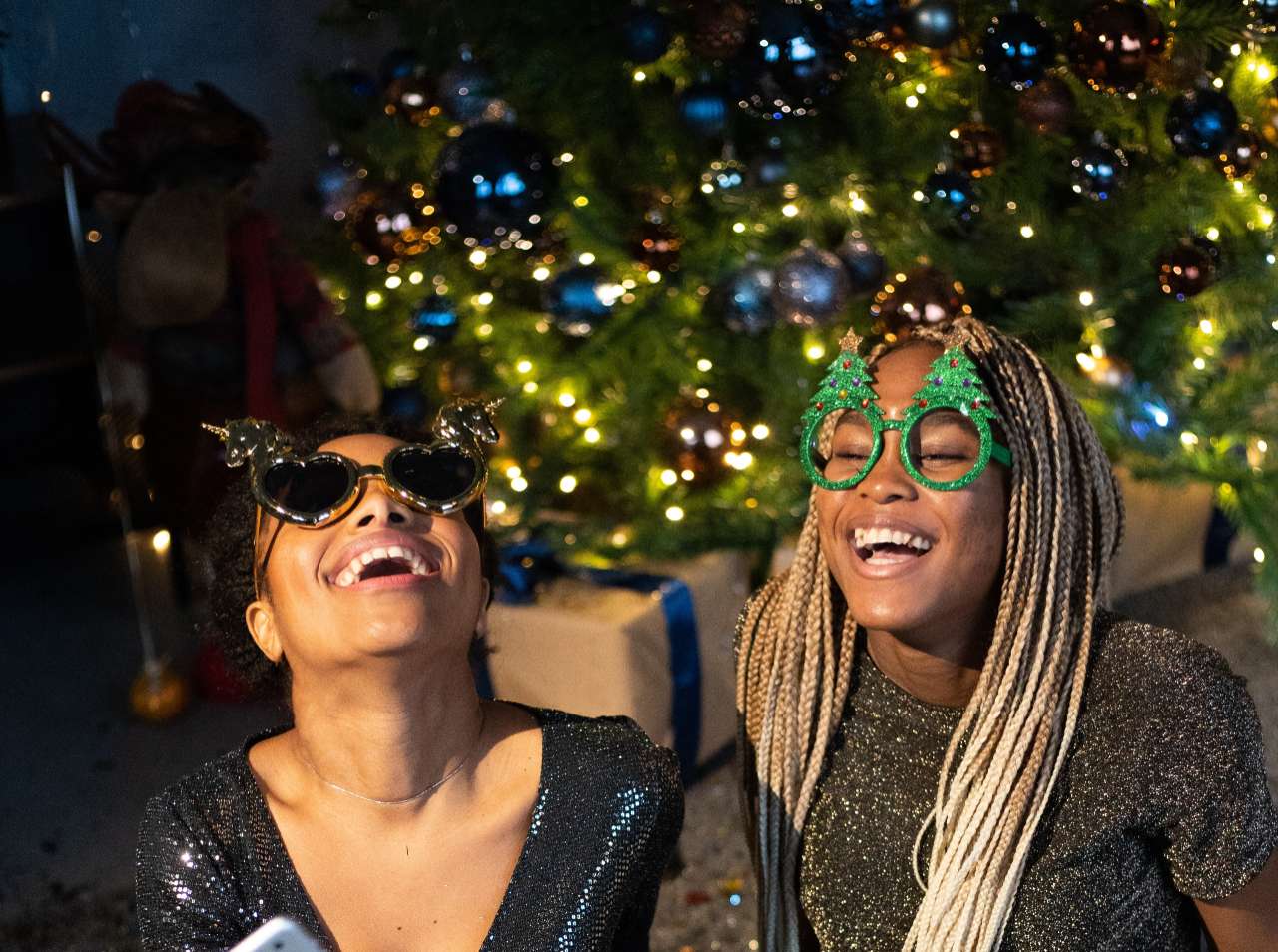 Two female friends in festive clothing laughing together